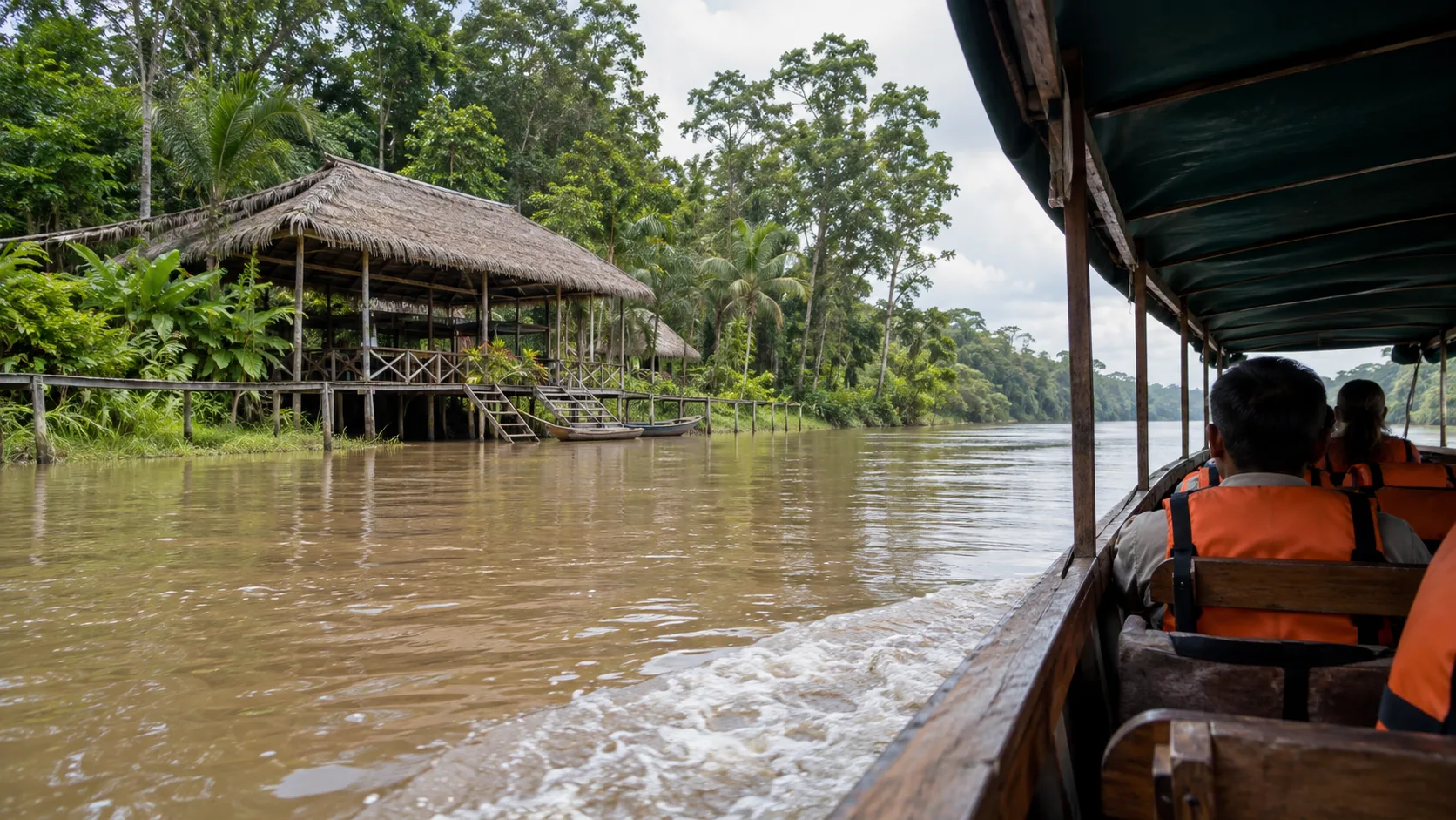 Covered river boat approaching a rainforest lodge near Iquitos, Peru